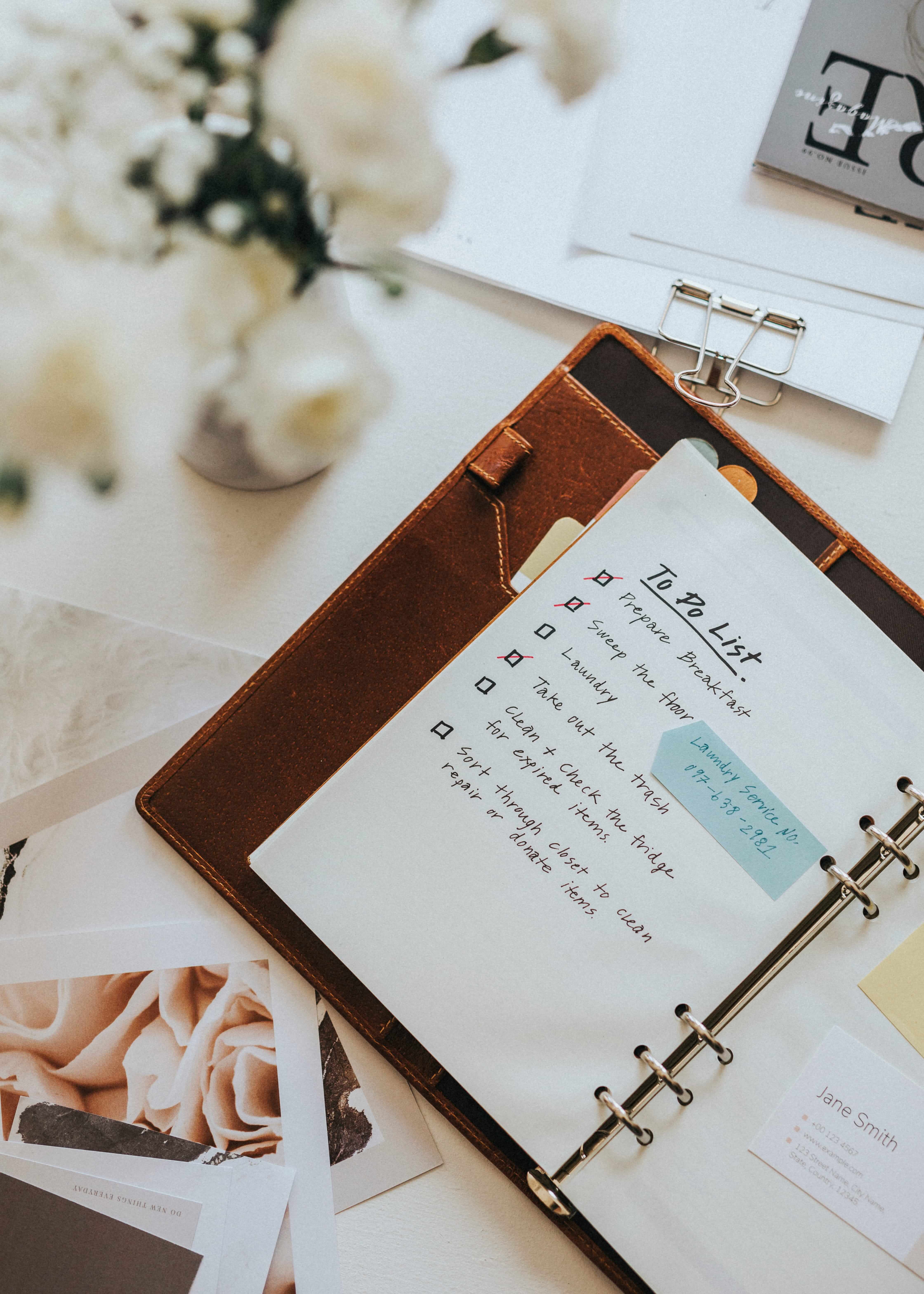 Couple planning their wedding with checklist, flowers, invitation cards and wedding details